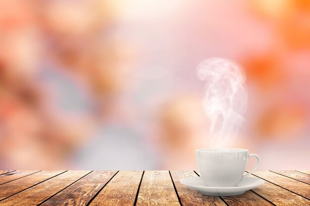 Горячий кофе на столе на весеннем фоне