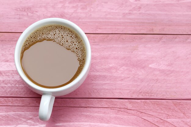 hot coffee in a white Coffee cup on Pink wooden table.