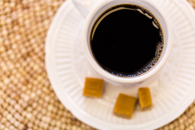 Caffè caldo con caramelle al caramello sul tavolo.