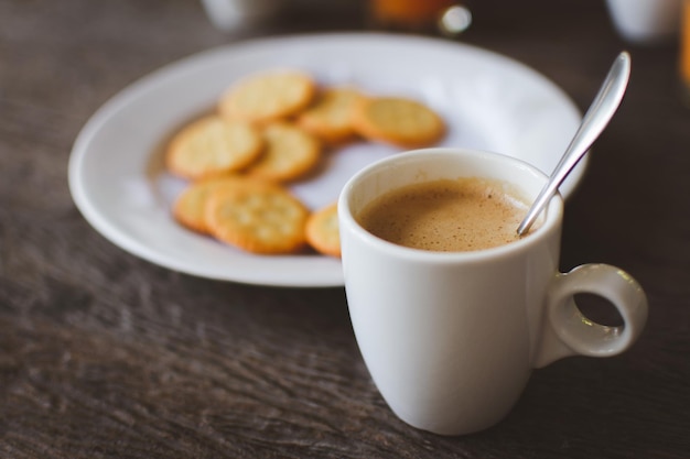 木製のテーブルにクラッカーとホットコーヒー