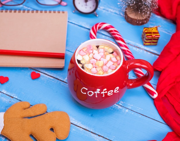 Hot coffee with marshmallow in a red ceramic mug 