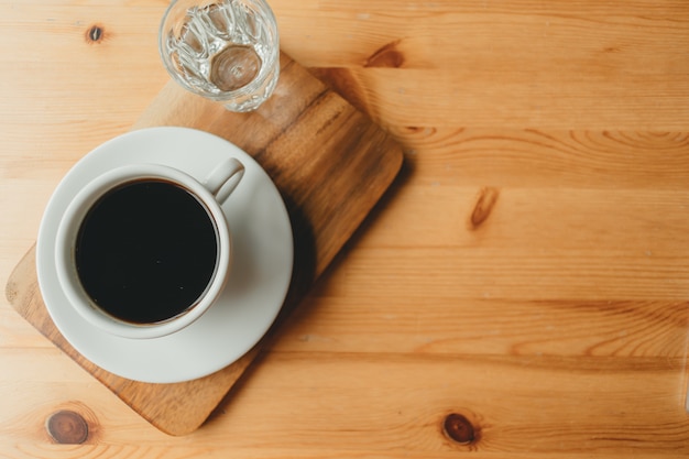 Hot cup of Americano coffee on wooden desk.