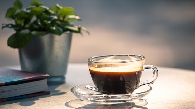 Hot cup of black coffee on table