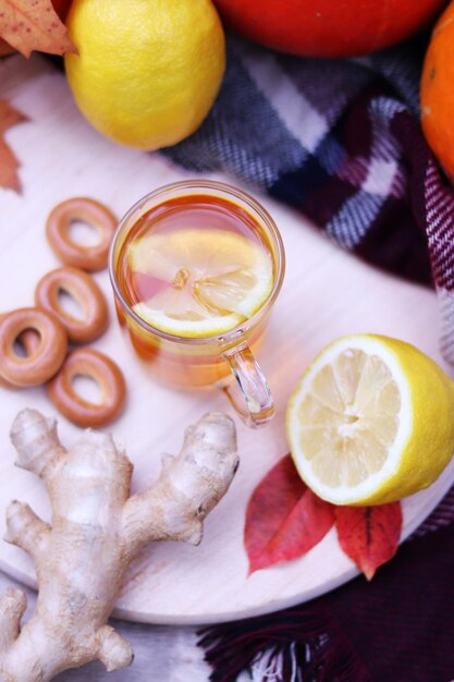 Hot cup of tea with autumn leaves, pumpkins, ginger, lemon and bagels. Autumn mood. Warming drink