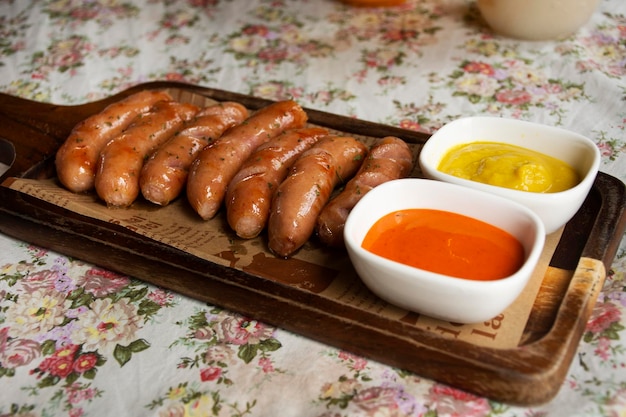 Hot dog german sausage and seasoning ketchup served on wooden tray for travelers thai people rest relax eat and drinks at cafe restaurant shop in Bangkok Thailand