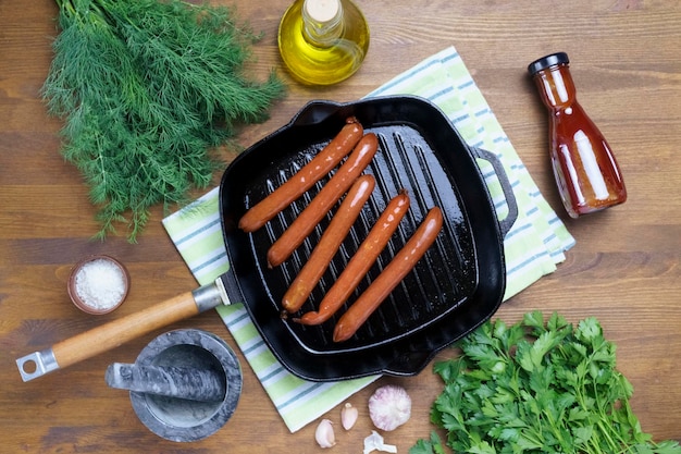 Hot dog sausages are fried in a grill pan