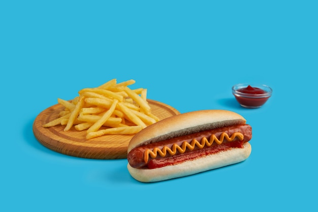 Hot dog with french fries on blue background restaurant cafe menu