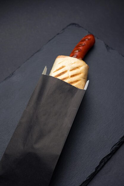 Hot dog with sausage on a black board