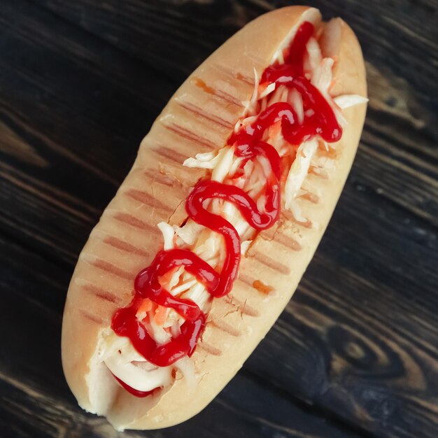 Hot dog with spicy sauce on dark backgroundphoto with copy space