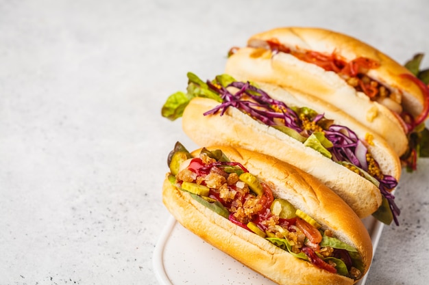 Hot dogs with assorted toppings on a white background, top view. 