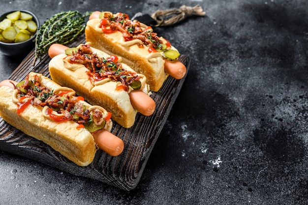 Hot dogs with different toppings. Dark Wooden table. Top view.  