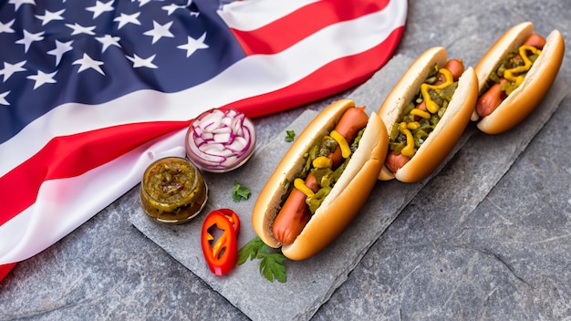 Photo hot dogs with vegetable garden relish on the stone table with american flag background generative ai