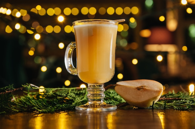 Hot drink cocktail for New Year, Christmas, winter or autumn holidays. Toddy. Mulled pear cider or spiced tea or grog with pear.