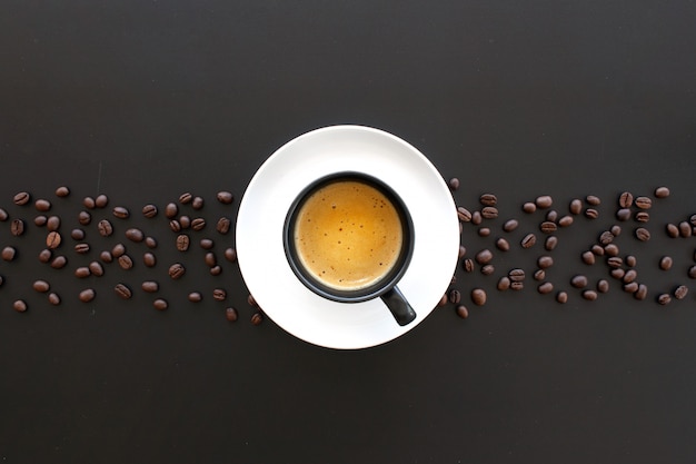 Hot espresso and coffee bean on black table 