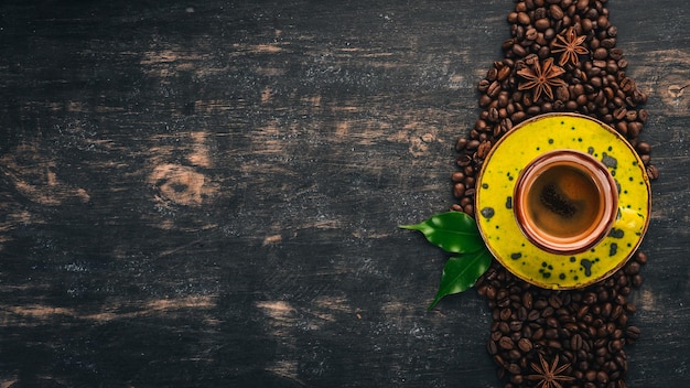 Hot espresso coffee in a cup Cinnamon On a black wooden background Top view Copy space