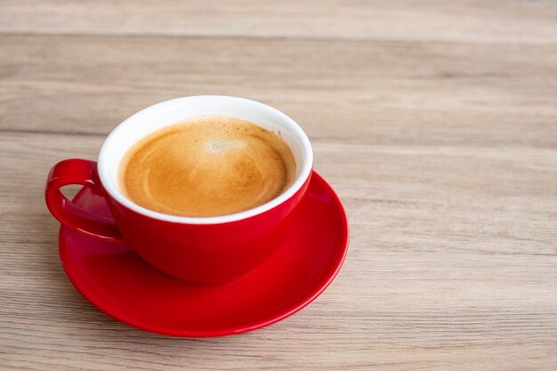 テーブルの上の熱いエスプレッソコーヒー、カフェや家の赤いコーヒーカップ。テキスト用の空白のコピースペースのある上面図。