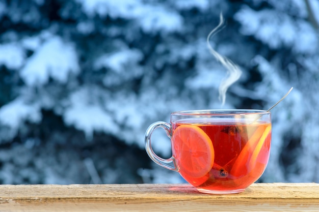 Foto tè caldo alla frutta con anelli di limone in una giornata fredda. inverno sfondo, copia spazio.