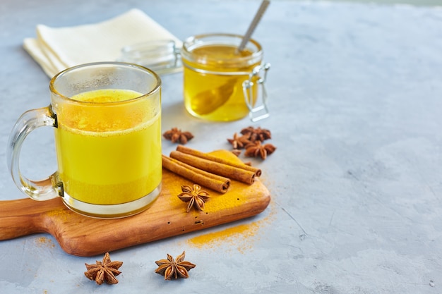 Latte caldo dorato con polvere di curcuma in bicchieri