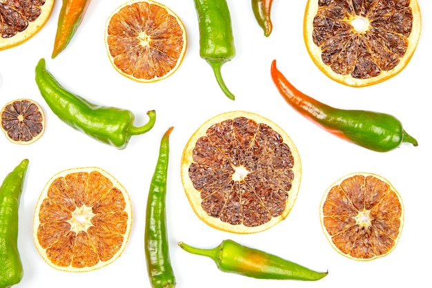 Hot green peppers and dried citrus fruit on a white background grocery organic flatley