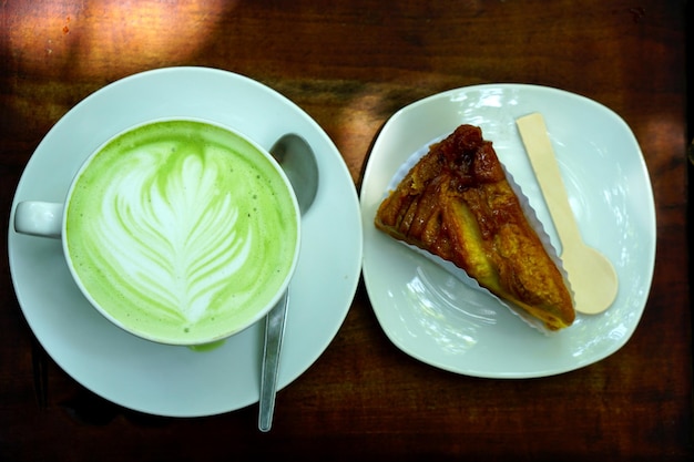 hot green tea and banana cake on wooden floor