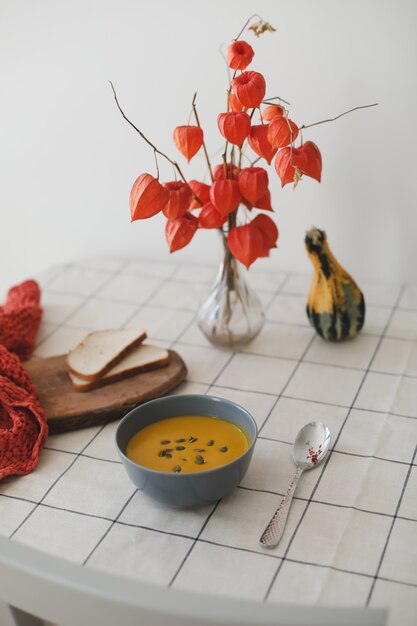 Hot healthy vegetarian pumpkin cream soup with seeds on the table