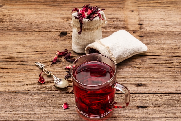 Hot hibiscus tea. Dry petals, linen sacks. Healthy food and self-care concept.