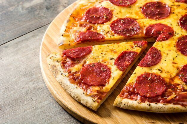 Hot italian pepperoni pizza on wooden table