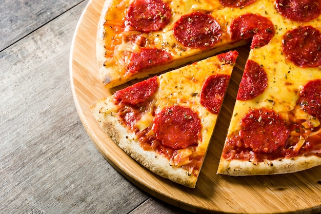 Hot italian pepperoni pizza on wooden table.