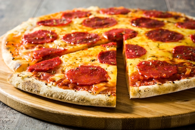 Hot italian pepperoni pizza on wooden table.