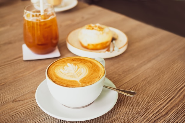 Hot late coffee in white cup and spoon wood table