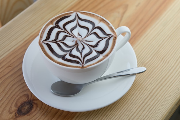 Caffè caldo di arte del latte in tazza bianca