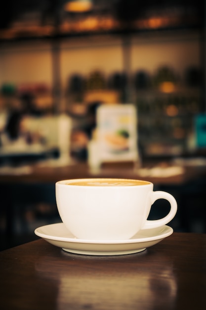 Foto caffè caldo latte in tazza bianca sul tavolo in ristorante e caffè