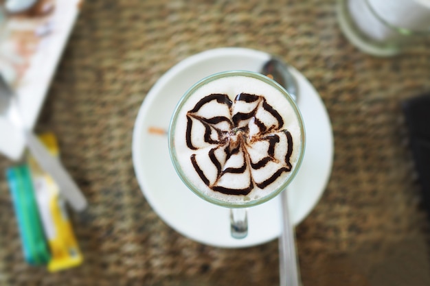 Hot latte coffee with topping in glass cup. 