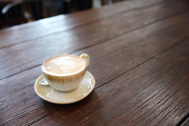 木の背景にホットラテコーヒー