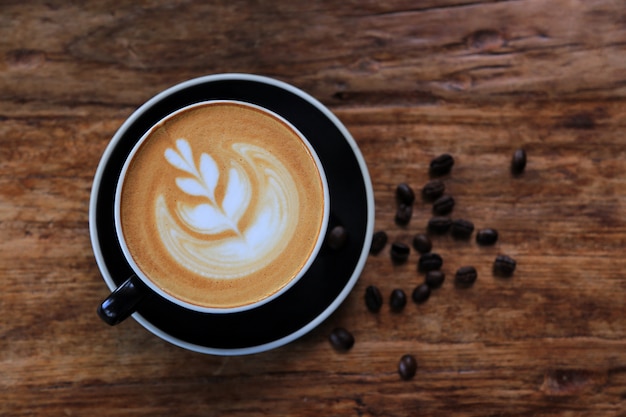 Hot Latte on Old Wood Floor in Black Glass