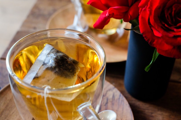 ガラスの熱いラベンダーの茶は木のスプーン及び受け皿と役立つ