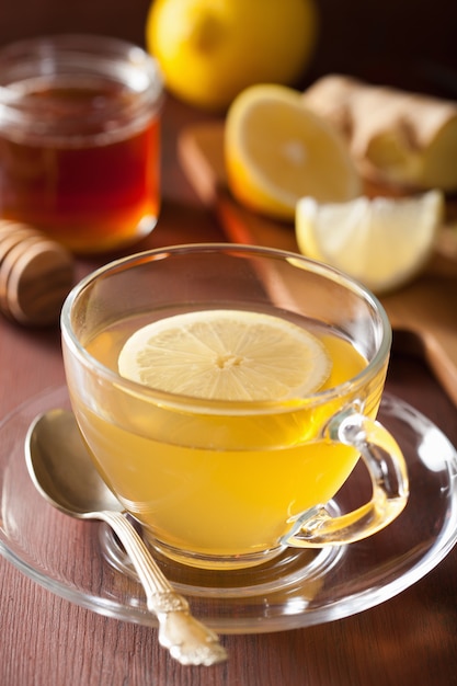 Hot lemon ginger honey tea in glass cup