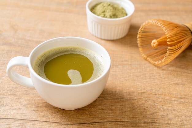 hot matcha green tea cup with green tea powder and whisk