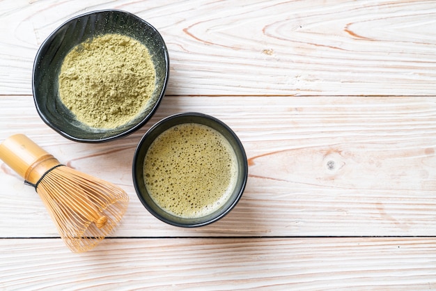 Foto tazza di tè verde matcha calda con polvere di tè verde e frusta