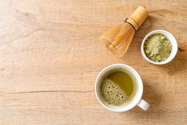 hot matcha green tea cup with green tea powder and whisk