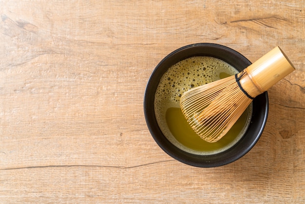 hot matcha green tea cup with green tea powder and whisk