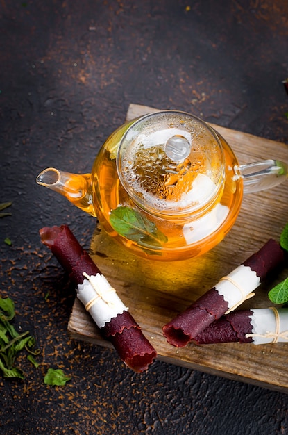 Hot mint tea in a tea pot and  dry fruits leather roll