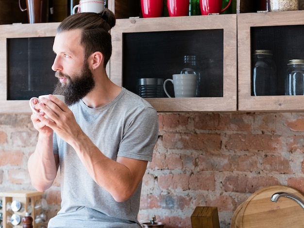 Hot morning drink enjoyment. new day. rise and shine. hipster with cup looking sideways thinking. contemplation.