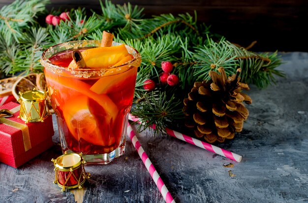 Hot mulled wine drink with orange, and christmas decorations