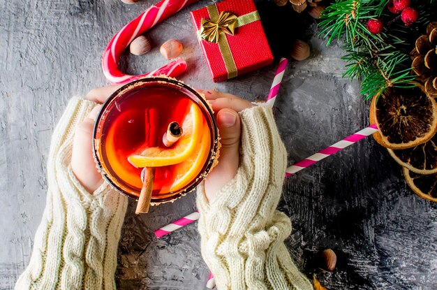 Hot mulled wine drink with orange and christmas decorations
