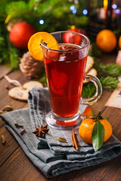 Photo hot mulled wine in a glass with spices and oranges