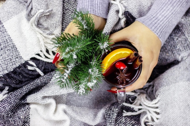 Hot mulled wine in male and female hands, spices.