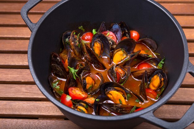 Hot mussels with sauce in coast iron