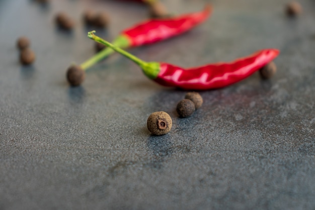 Hot peppers with spices on wooden table close up