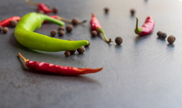 Hot peppers with spices on wooden table close up